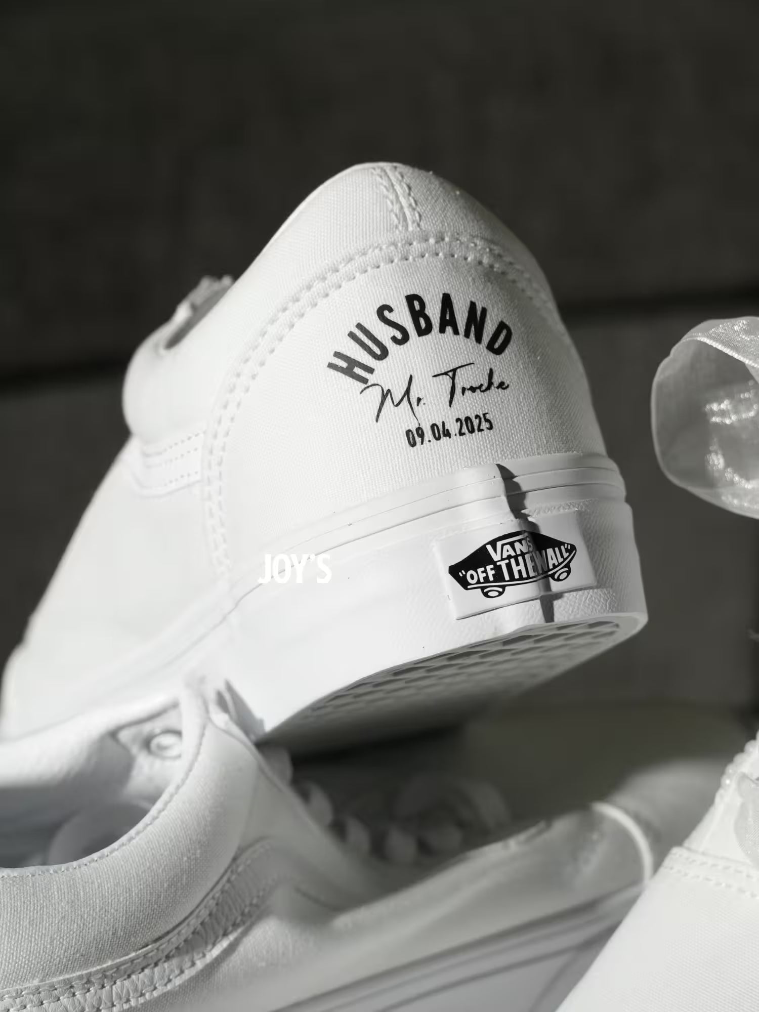 White Vans custom wedding sneakers with “Husband and wedding date printed on the heels, shown in a rear view on a Vans shoebox