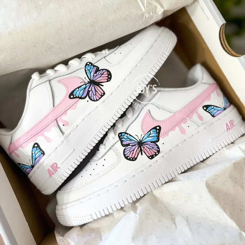 Custom hand-painted Nike Air Force 1 Low sneakers with pastel butterfly artwork and pink swoosh details.