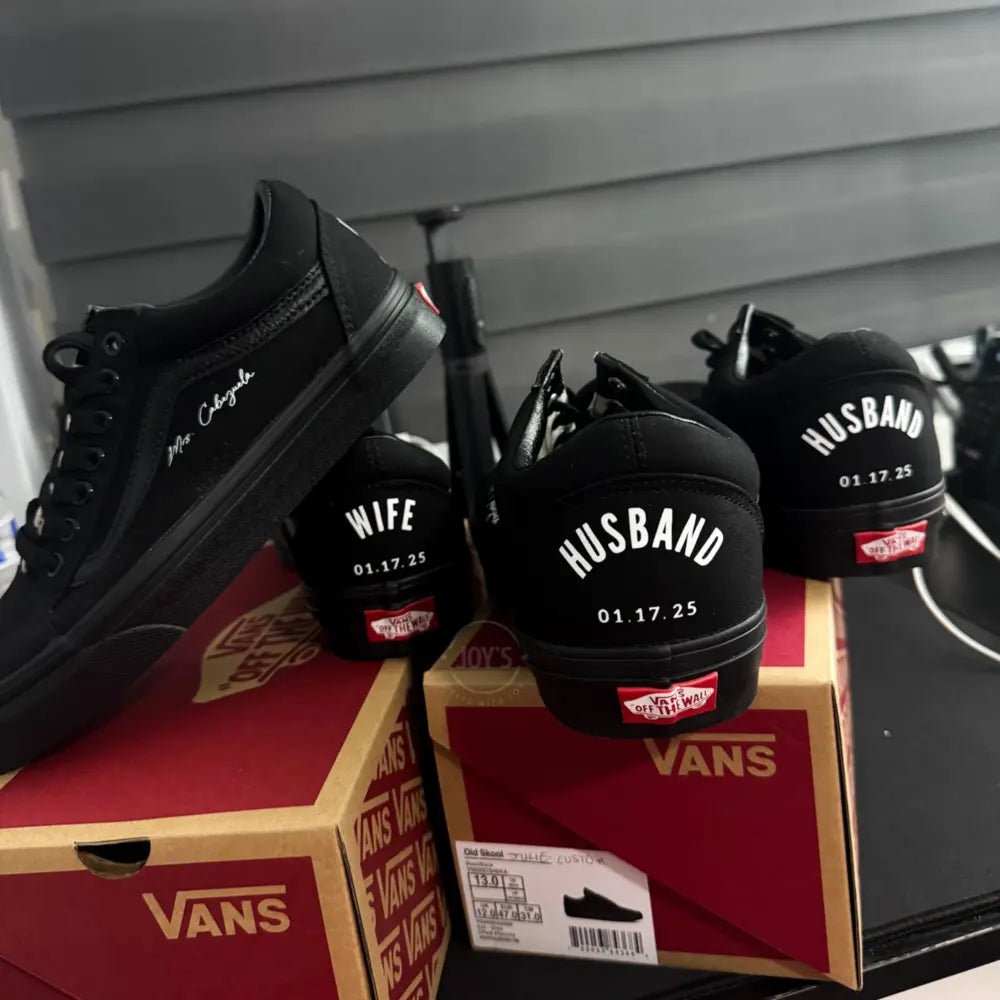 Black Vans custom wedding sneakers with “Husband and wedding date printed on the heels, shown in a rear view on a Vans shoebox
