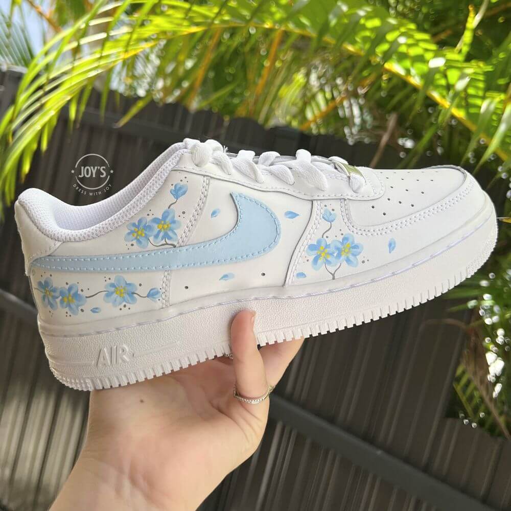 Nike Air Force 1 sneakers with blue swoosh, floral details