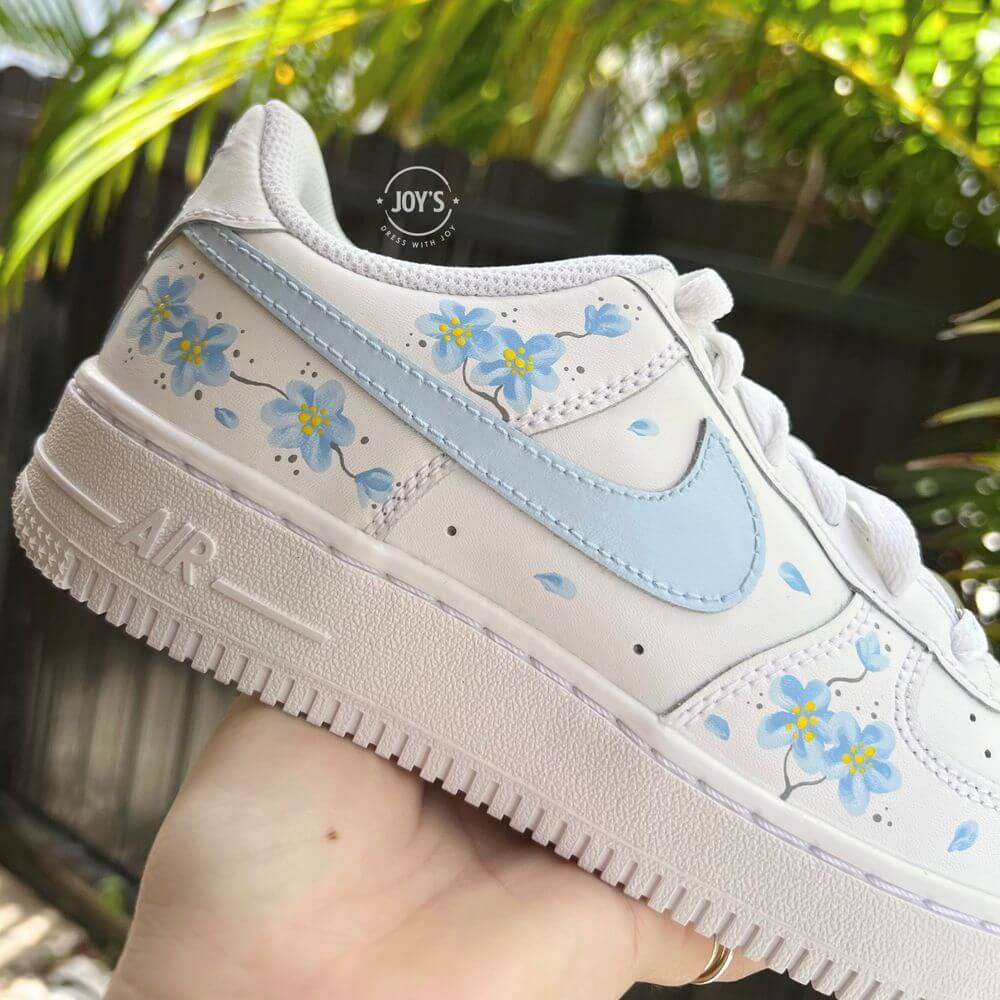 Nike Air Force 1 sneakers with blue swoosh, floral details