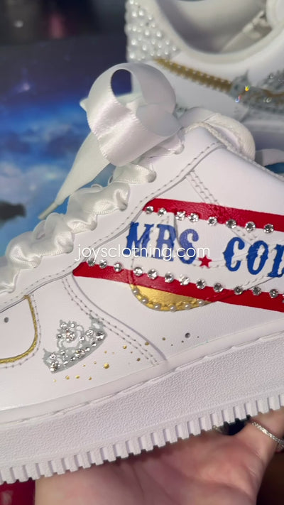 White custom wedding sneakers with pearl-embellished heel, rhinestone details, red and blue painted accents, and personalized “Mrs. Colorado” text on the side, shown in a close-up side view