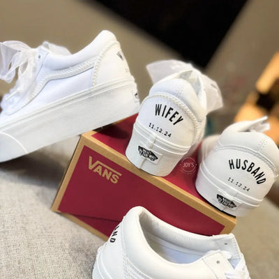 White platform Vans wedding sneakers with pearl trim, satin ribbon laces, and personalized “Mrs.” and last name with wedding date printed on the heels, shown in a rear view