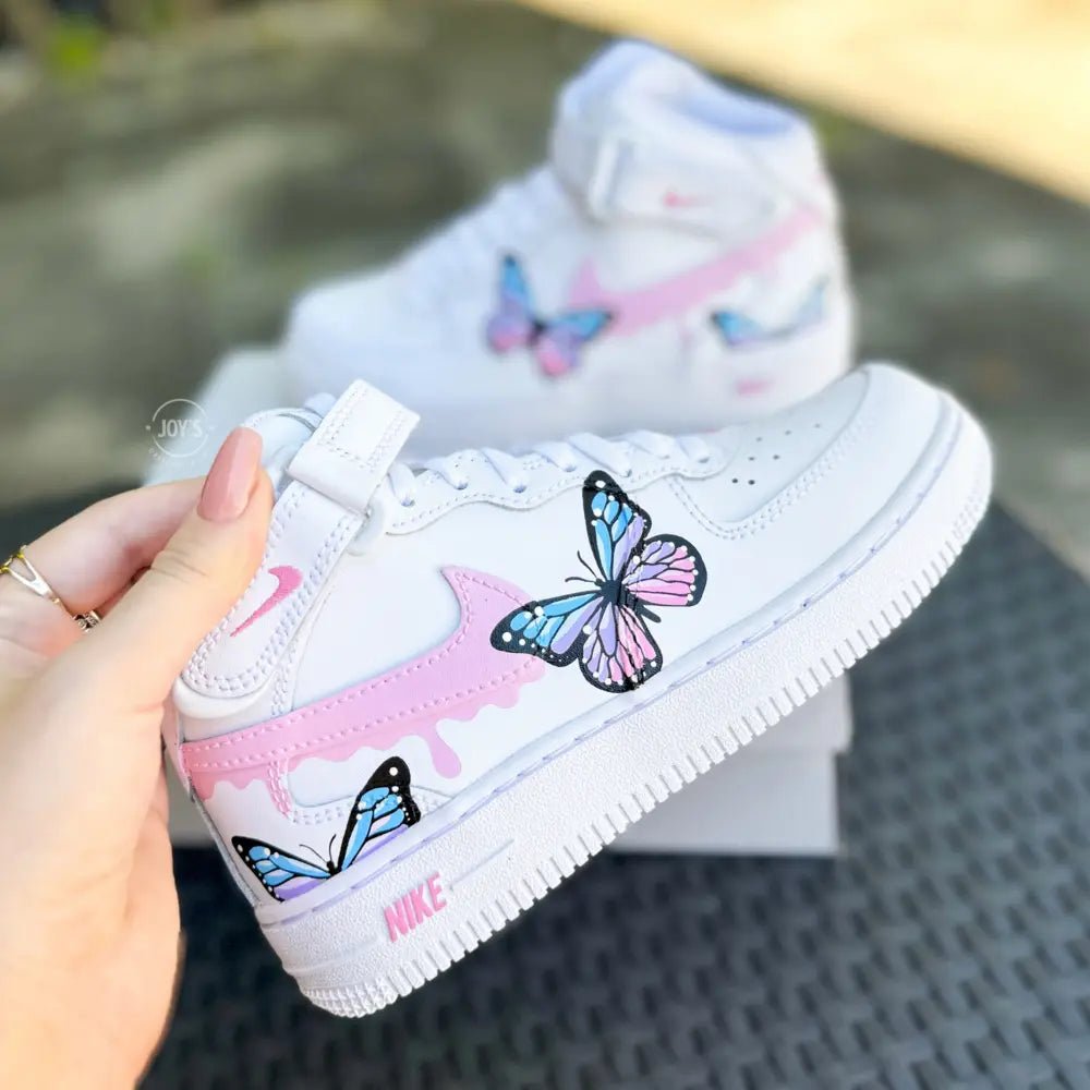 Custom hand-painted Nike Air Force 1 Mid baby sneakers with pastel butterfly artwork and pink details.